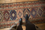 Distressed vintage Malayer runner showing geometric Moghan guls in sapphire blue, terra cotta.
