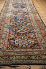 Distressed Malayer runner featuring geometric guls in navy, terra cotta, and ivory.