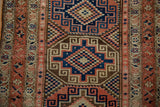 Distressed pile and geometric Moghan style guls in navy, terra cotta, and ivory on the Malayer runner.