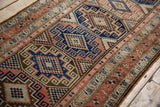 Distressed Malayer runner close-up: Moghan geometric guls and border in sapphire, terra cotta, ivory.