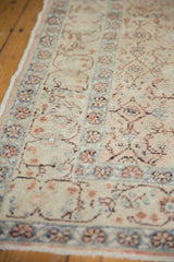 Muted beige field with powder blue and peach floral motifs on a distressed Kayseri runner.