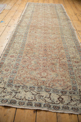 Distressed Kayseri runner end with faded floral cross-sections and short fringe.