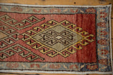 Distressed Oushak runner corner with red abrashed field and blue floral vine border.
