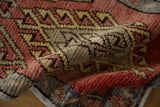 Distressed Oushak runner pile texture in brick red, saffron yellow, ivory with hook and latch motif.