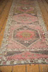 Evenly worn texture showing geometric motifs of a vintage Oushak in rose and charcoal.