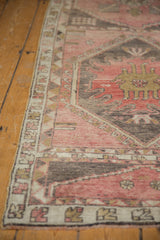 Distressed Oushak rug runner, showing faded dusty rose, charcoal, and bronze geometric patterns.