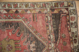 Textured vintage Oushak rug runner with distressed rose, bronze, and charcoal patterns.