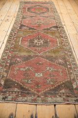 Vintage distressed Oushak runner end, showing secured fringe, pale raspberry, and bronze colors.