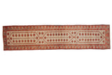 Distressed vintage Oushak runner with elongated geometric medallions in ivory, muted red, and silver-beige.