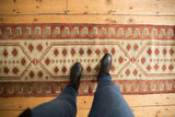 Distressed vintage Oushak runner with ivory, raspberry, and beige geometric patterns.