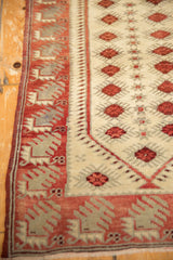 Distressed Oushak runner side showing red geometric border and ivory patterned field.