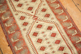 Textured ivory field with dusty raspberry pomegranate and starburst motifs on Oushak runner.