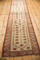 Oushak runner corner, distressed low pile, ivory field, raspberry geometric border, secured edge.
