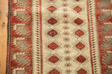 Distressed ivory field and red starburst motifs on a vintage Oushak rug runner.
