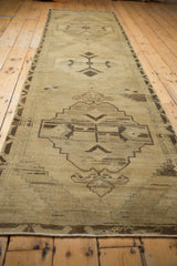Fully secured fringe on a vintage distressed Oushak rug runner, with soft neutral tones.