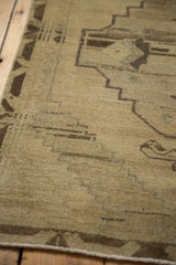 Distressed wool pile of a vintage Oushak runner, featuring a faded primitive geometric design.
