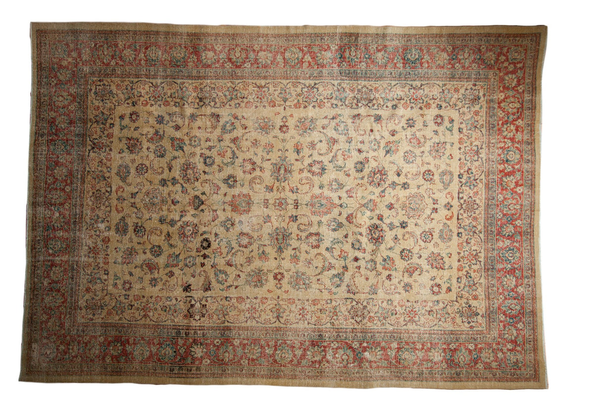 Distressed vintage Tabriz carpet with scrolling leaves on a pale gold field and a cherry red border.