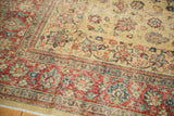 Intricate palmettes in the cherry red and blue border of a distressed vintage Tabriz carpet.