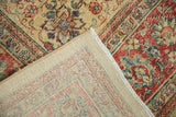 The hand-knotted foundation and distressed floral pile of a vintage Tabriz carpet corner.
