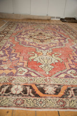 A low-angle view showing the time-softened pile and colors of a vintage distressed Oushak carpet.