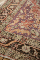 Worn hand-knotted texture of a vintage Oushak carpet in violet purple, sand, and tangerine orange.