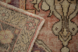 The hand-knotted foundation and wool pile texture of a distressed vintage Turkish Oushak carpet.