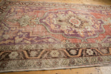 Low-pile texture and detailed ornamental border of a vintage distressed Oushak carpet.
