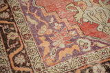 Distressed Oushak corner detail with violet purple spandrels and tangerine orange florals.