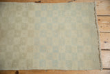 Distressed Oushak runner's muted checkered pattern, heavy abrashes, and visible side selvage.