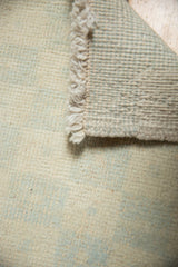 Distressed Oushak rug close-up: even pile wear, fringe, abrash, and woven backing.