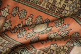 Textured close-up of distressed Dosemealti runner, rust field with geometric floral relief.