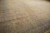 Distressed Oushak rug with worn pile texture, ivory field, and pale blue floral motifs.