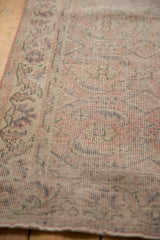 Distressed texture of vintage Sparta rug runner with faded rose and oxidized silver motifs.