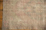 Distressed Oushak rug texture, showing knot heads, pale mauve, seafoam, and ivory.