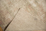 Textured, distressed pile and hand-knotted foundation of a vintage Oushak rug runner.