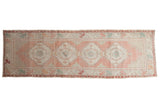 Distressed Oushak runner, stepped medallions, geometric motifs, abrashed dusty rose and seafoam tones.