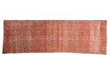 Distressed Oushak runner in faded raspberry, open field texture with faint foundation showing.