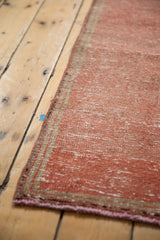 Close-up of the distressed dusty raspberry Oushak rug runner's textured pile and secured edge.