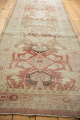Distressed Oushak runner, detailed medallions, dusty red, ivory, and even pile wear.