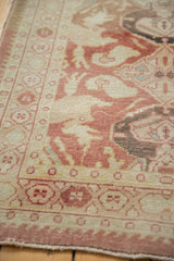 Vintage distressed Oushak runner's geometric border with blush, ivory field and even wear.