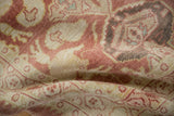 Detailed view of the distressed Oushak rug's even wear, revealing blush, ivory, and subtle green motifs.