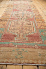 A low-angle view along the distressed Oushak runner reveals its column of stepped medallions.