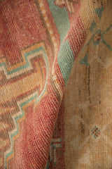 A folded view showing the low, worn pile and hand-knotted texture of a vintage Oushak rug.