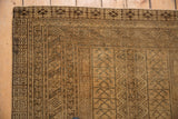 Distressed Turkmen rug corner with germinating plant and crab patterns, in beige gold and charcoal.