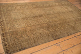 Distressed Turkmen rug corner with rams horn border and beige gold patterns.