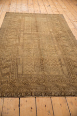 Chocolate brown rams horn outer border and distressed texture of the vintage Turkmen rug.