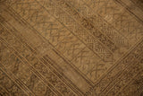 Distressed beige gold and brown geometric patterns, worn texture of a vintage Turkmen rug.