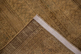 Folded corner of a distressed Turkmen rug shows its intact selvage and even worn brown pile.