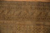 Distressed vintage Turkmen rug border, beige gold geometric, plant, and crab patterns.