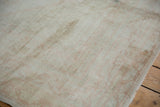 Distressed Oushak rug detail: faded pale blush patterns on an ivory field with even wear.
